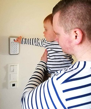 Pappa og sønn sjekker alarmsystemet i huset 350x420.jpg